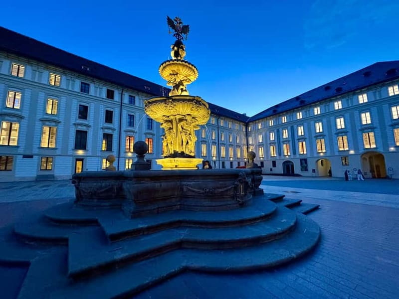 Prague: Night Walk through Prague Castle with City Views - Crossing Prašný Bridge and entering the royal courtyards