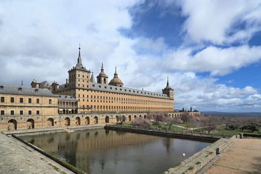 San Lorenzo de El Escorial: Monastery and Site Guided Tour - Entering through the main door with the Spanish flag
