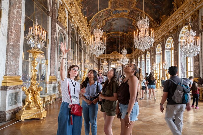 Visitors under the gilded ceiling of the Hall of Mirrors at Versailles